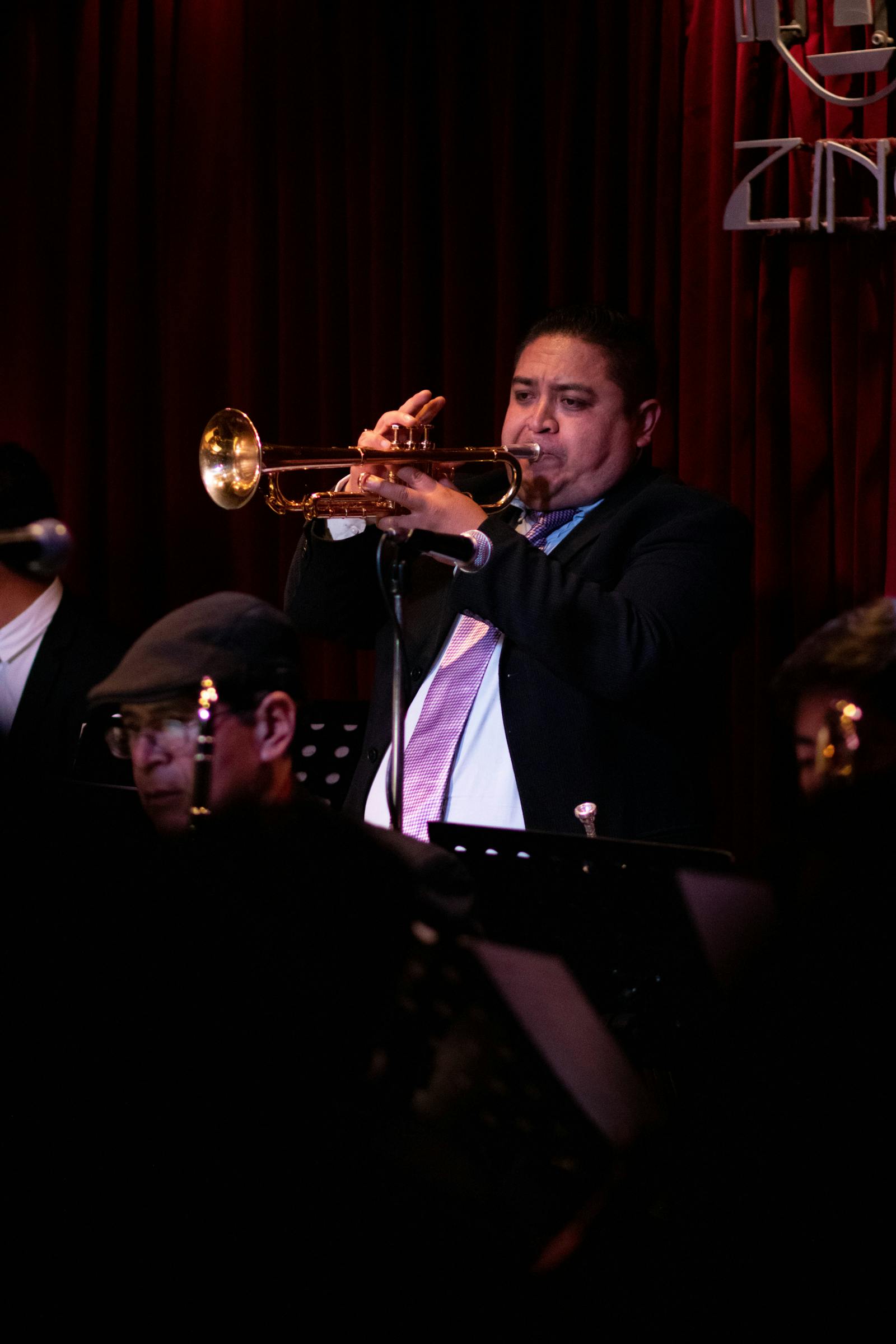Musicien de jazz concentré sur son instrument dans une lumière chaude