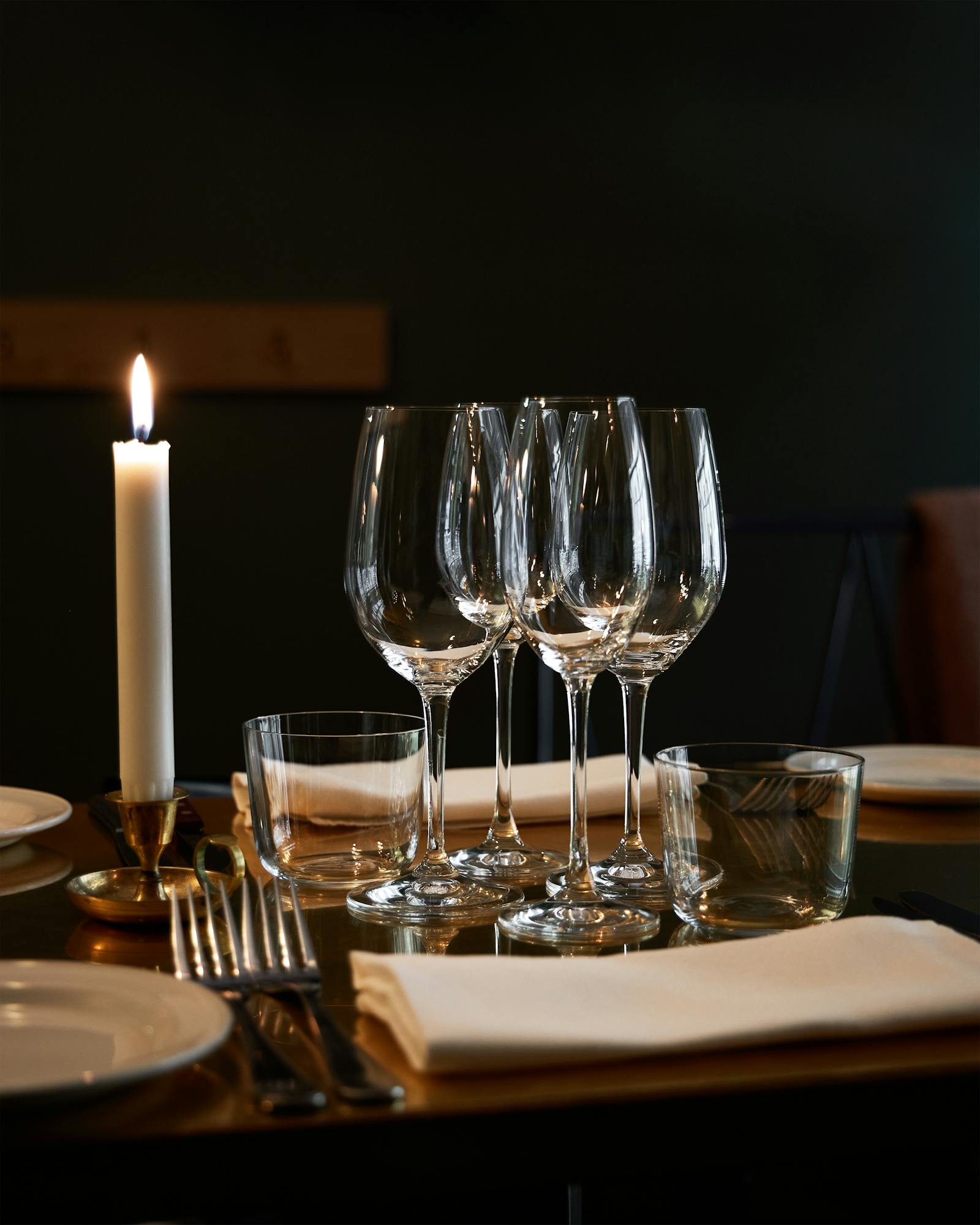 Table dressée pour le dîner avec bougies allumées et verres à pied
