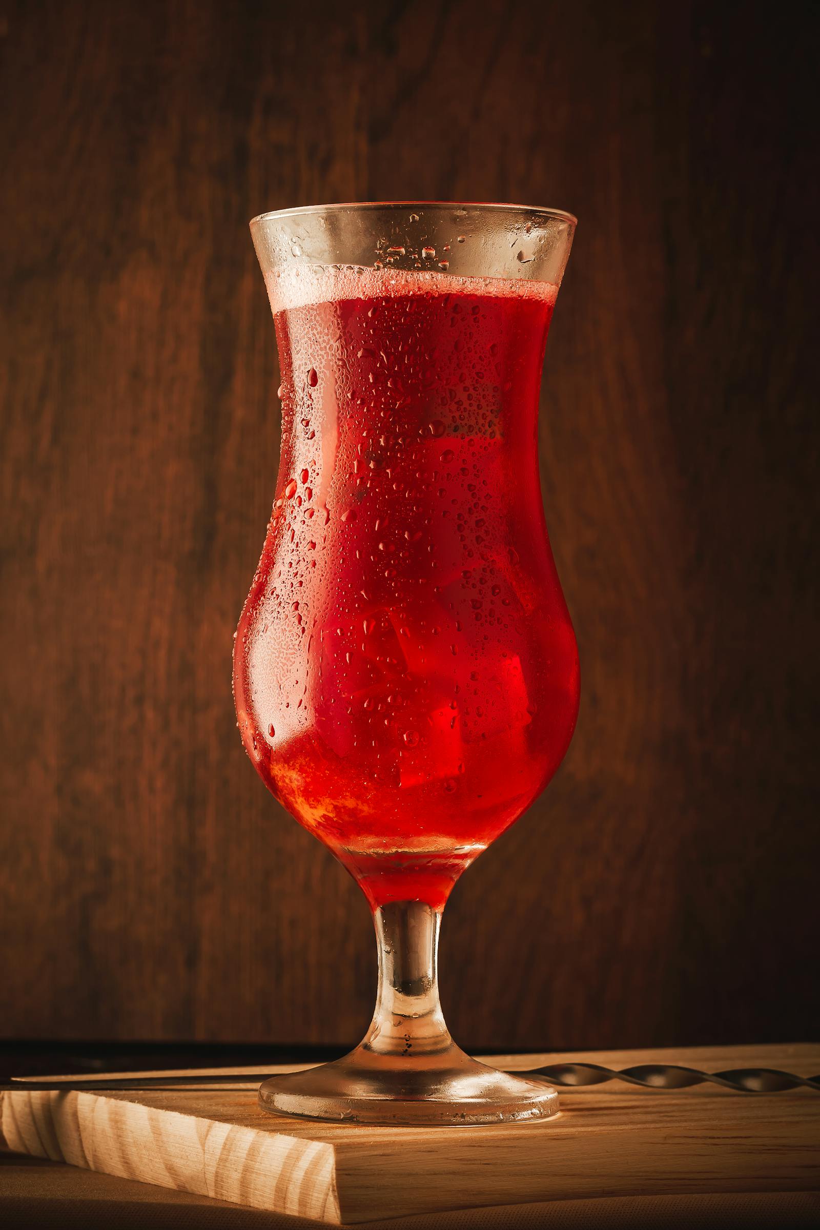 Cocktail Hurricane rouge avec grenade et fleur d'oranger