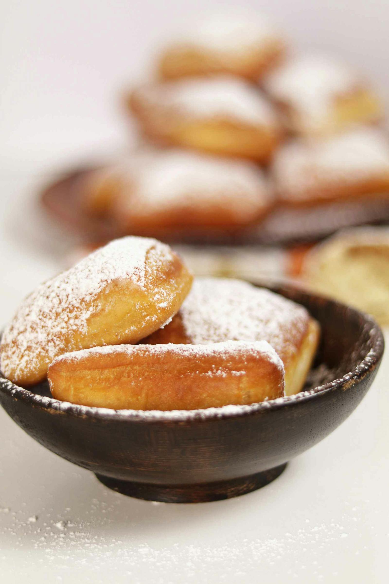 Beignets tièdes saupoudrés de sucre glace avec crème à la chicorée